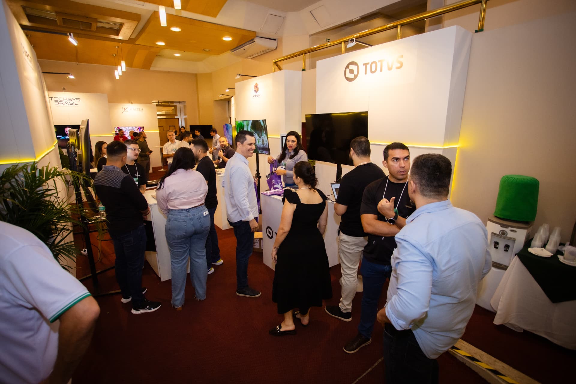 Participantes conversando com empresas expositoras no Fórum TINE