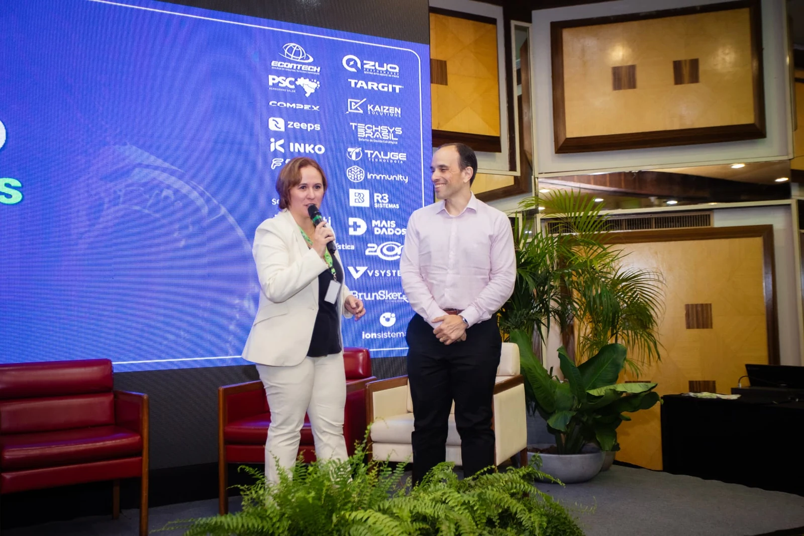 Palestra na Arena de Conteúdo, com o painel de marcas parceiras ao fundo